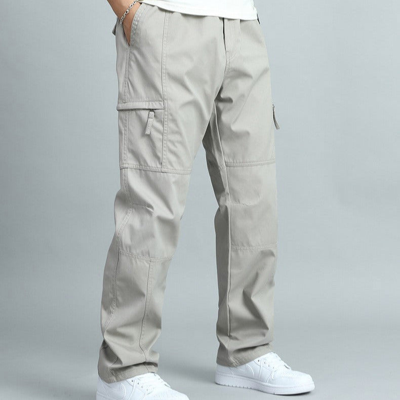 Man crouching, showcasing flexibility & multi-pockets of rugged outdoor cargo pants.
