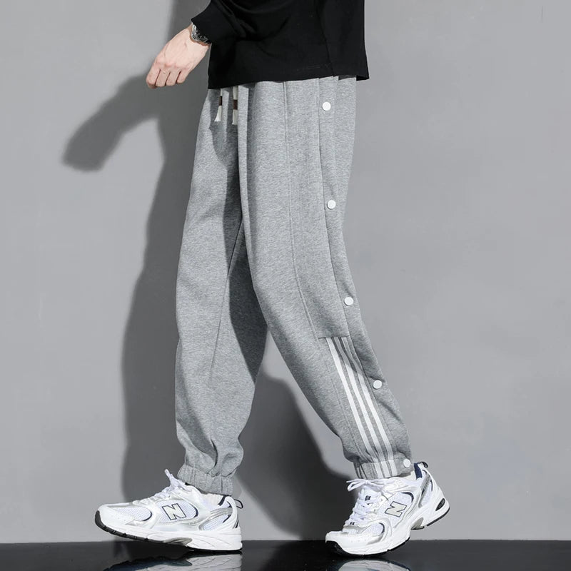 Modern men's snap-track joggers offering effortless comfort. Stylish casual pants with a relaxed fit for men's fashion.