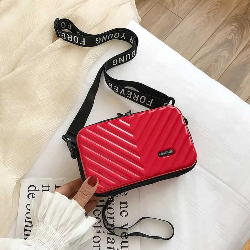 Modern women's compact hard shell crossbody travel bag. Secure & chic mini handbag, perfect for travel & daily use.