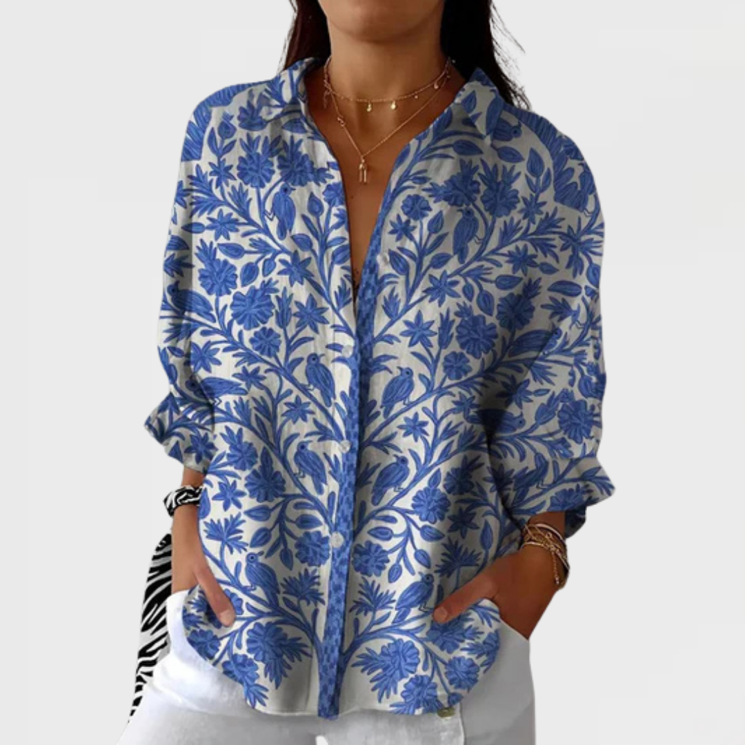 Women's elegant blue garden floral print blouse with long sleeves and cream base. Versatile chic style.