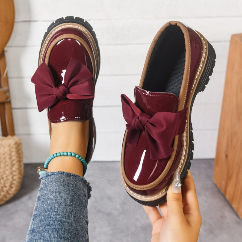 Pair of women's Lucente black patent bowknot loafers, comfortable slip-on flats with a stylish platform sole.
