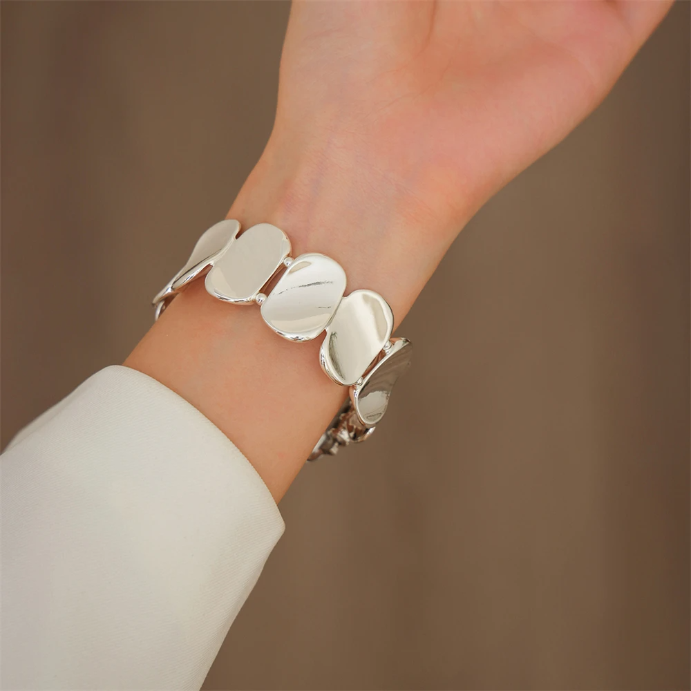 Sleek silver sculpted metal watch band, an essential jewelry-style accessory for women.