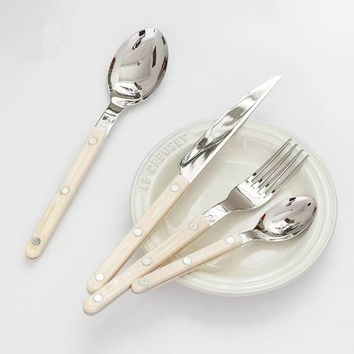 Durable 24-piece stainless steel flatware set, showcasing intricate engraved detailing for any meal.