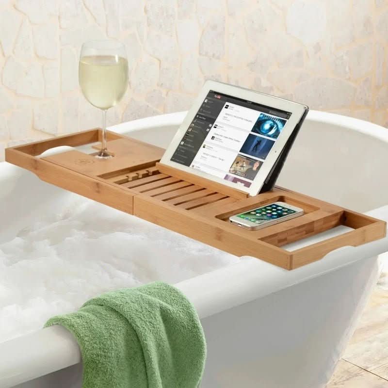 Extendable bamboo bathtub tray with phone holder, book stand, & candle slot for ultimate home spa relaxation.