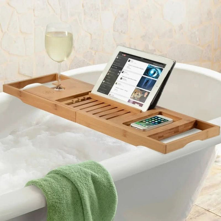 Extendable bamboo bathtub tray with phone holder, book stand, & candle slot for ultimate home spa relaxation.
