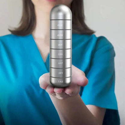 Open 7-day aluminum pill organizer showing individual compartments for daily medication.