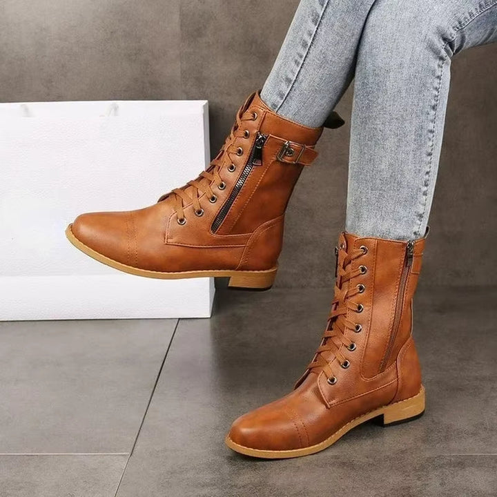 Grey women's mid-calf boots with multiple buckles & side zipper, ideal for an edgy fashion look.