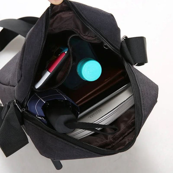 Black men's waterproof shoulder bag with anti-theft features for daily essentials.