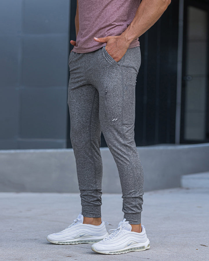 Men's performance stretch joggers, black, with phone in pocket, functional design.