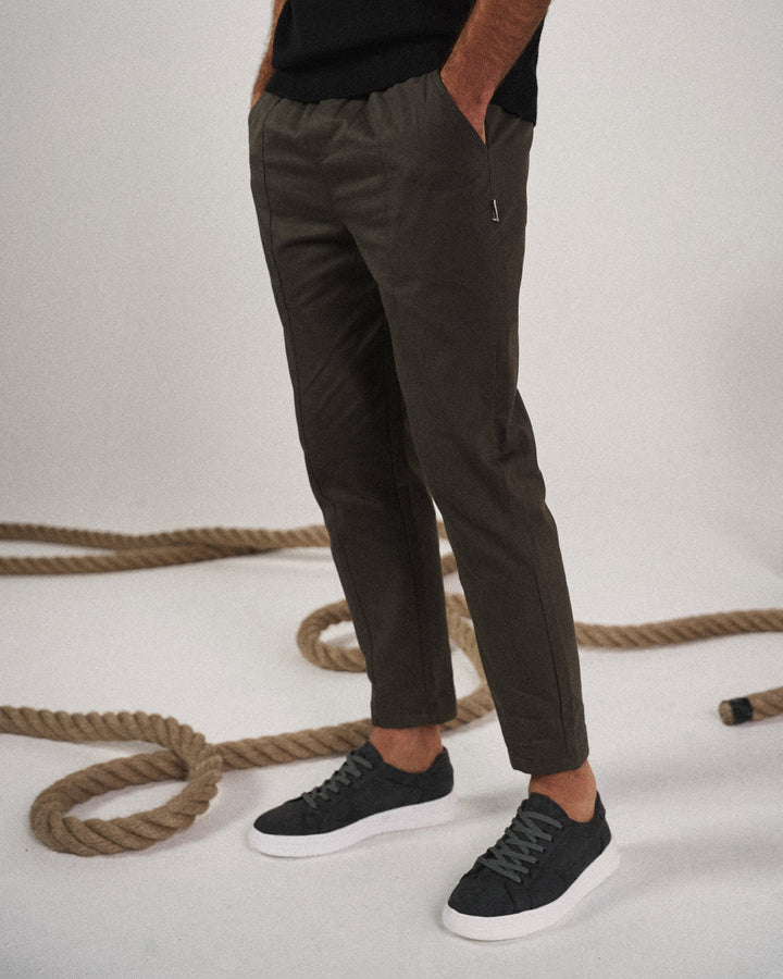 Man in relaxed pose wearing comfortable men's tapered joggers, suitable for active or leisure days.