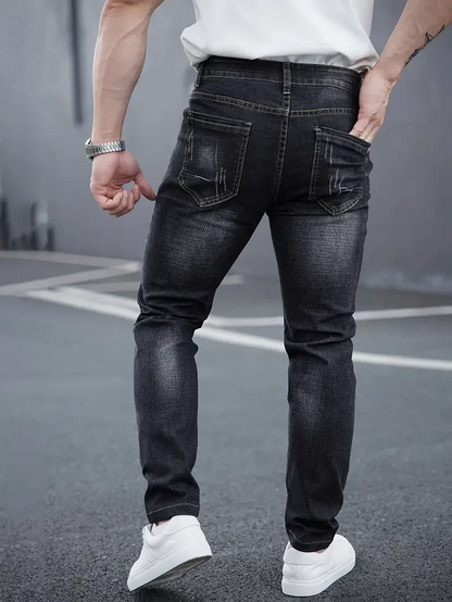 Distressed blue men's tapered jeans, offering a modern slim fit for streetwear.