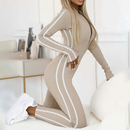 Full-length gray women's Velocity lounge jumpsuit. Slim-fit one-piece activewear with front zipper, perfect for comfort.