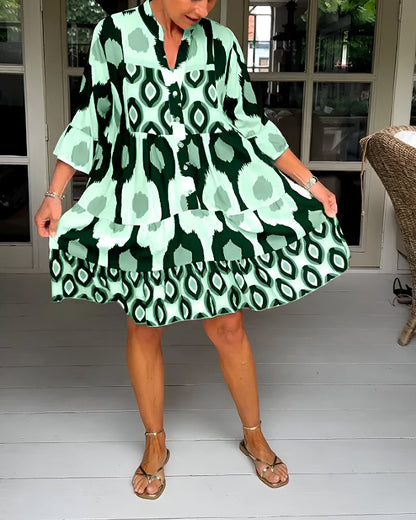 Casual women's bohemian maxi dress featuring a vibrant geometric print, tiered design, and stylish ruffle cuffs.