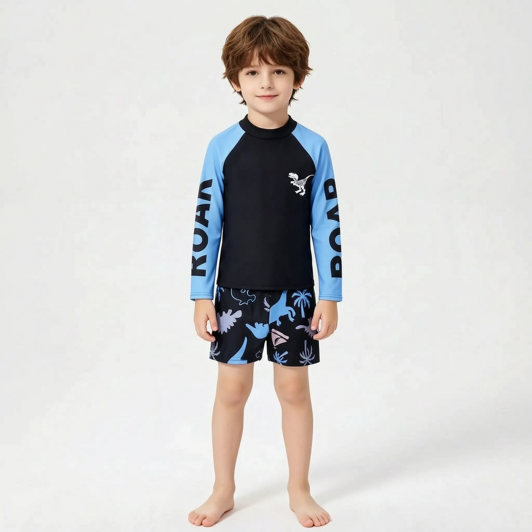 Close-up of boys' dinosaur long sleeve rash guard with matching blue swim shorts, a complete 2-piece set.