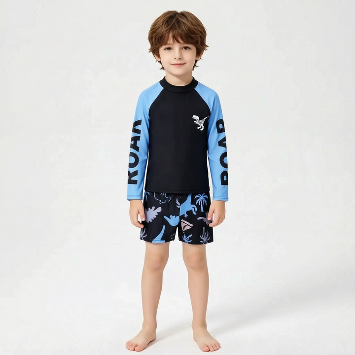 Close-up of boys' dinosaur long sleeve rash guard with matching blue swim shorts, a complete 2-piece set.