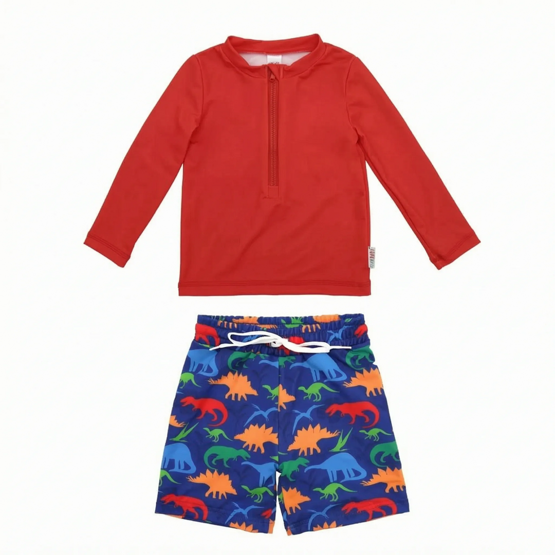 Happy toddler boy wearing a marine print UPF 50+ long-sleeve rash guard & swim trunks set for pool fun.