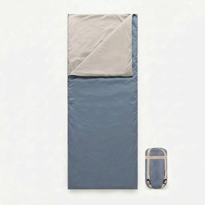 Rolled brown compact envelope sleeping bag, ideal for lightweight travel & hiking trips. Unisex design for outdoor recreation.