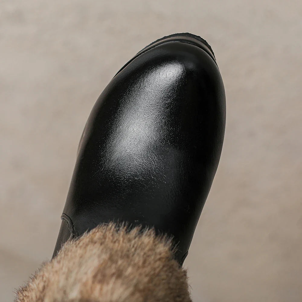 Close-up of a women's black heeled ankle boot, highlighting the stylish buckle and sleek design.