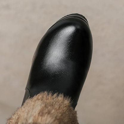 Close-up of a women's black heeled ankle boot, highlighting the stylish buckle and sleek design.
