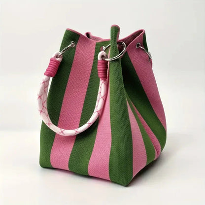 Close-up of the unique patchwork & striped design on a chic canvas mini bucket bag for women. Modern accessory.