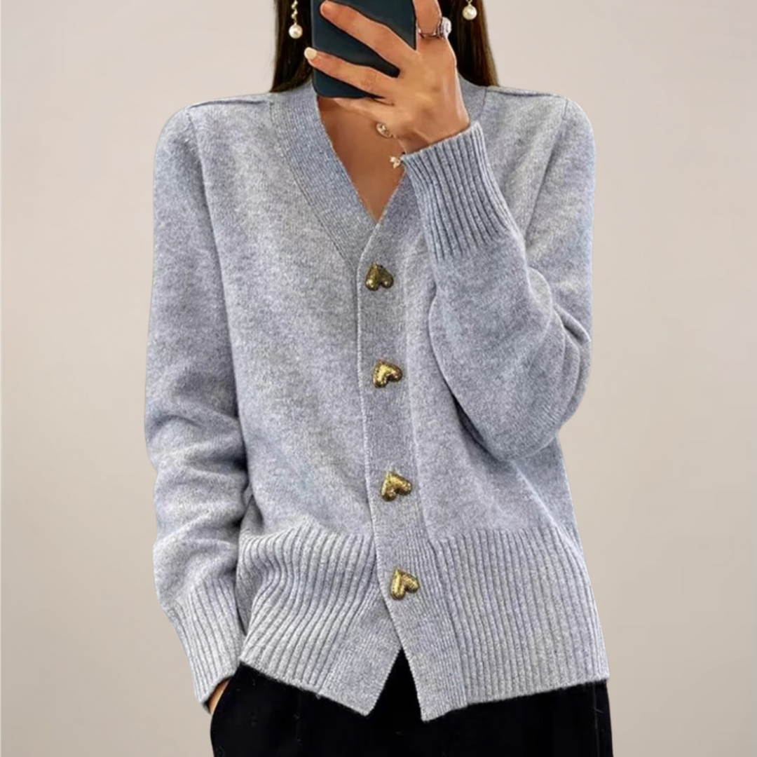 Relaxed fit women's knit cardigan. Elegant long sleeve sweater with subtle gold heart button accents for chic layering.