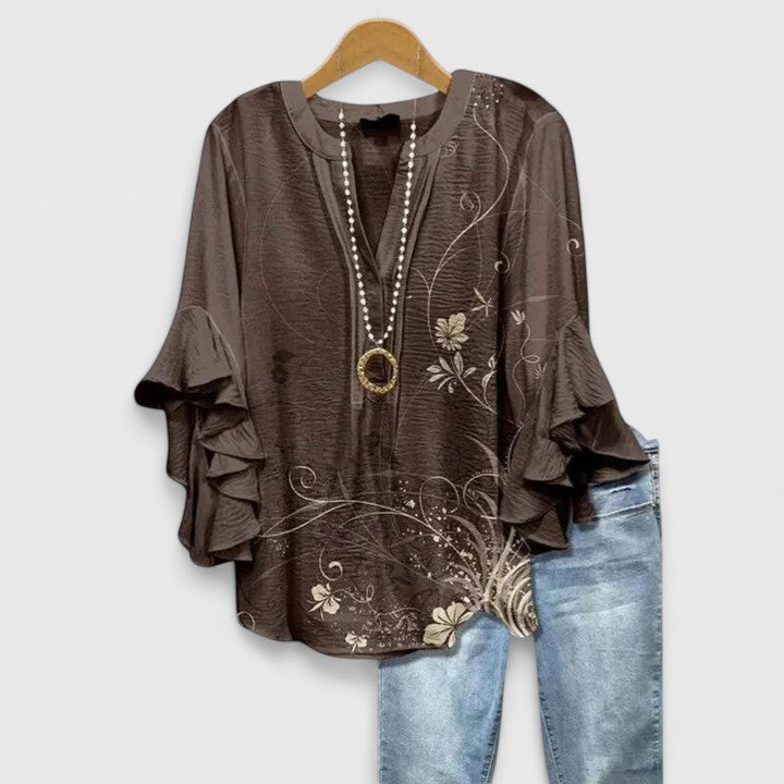 Fashionable women's blouse with a vibrant floral print and feminine ruffled sleeves, a summer essential.