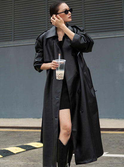 Close-up of elegant women's long trench coat fabric and button details, showcasing quality outerwear.