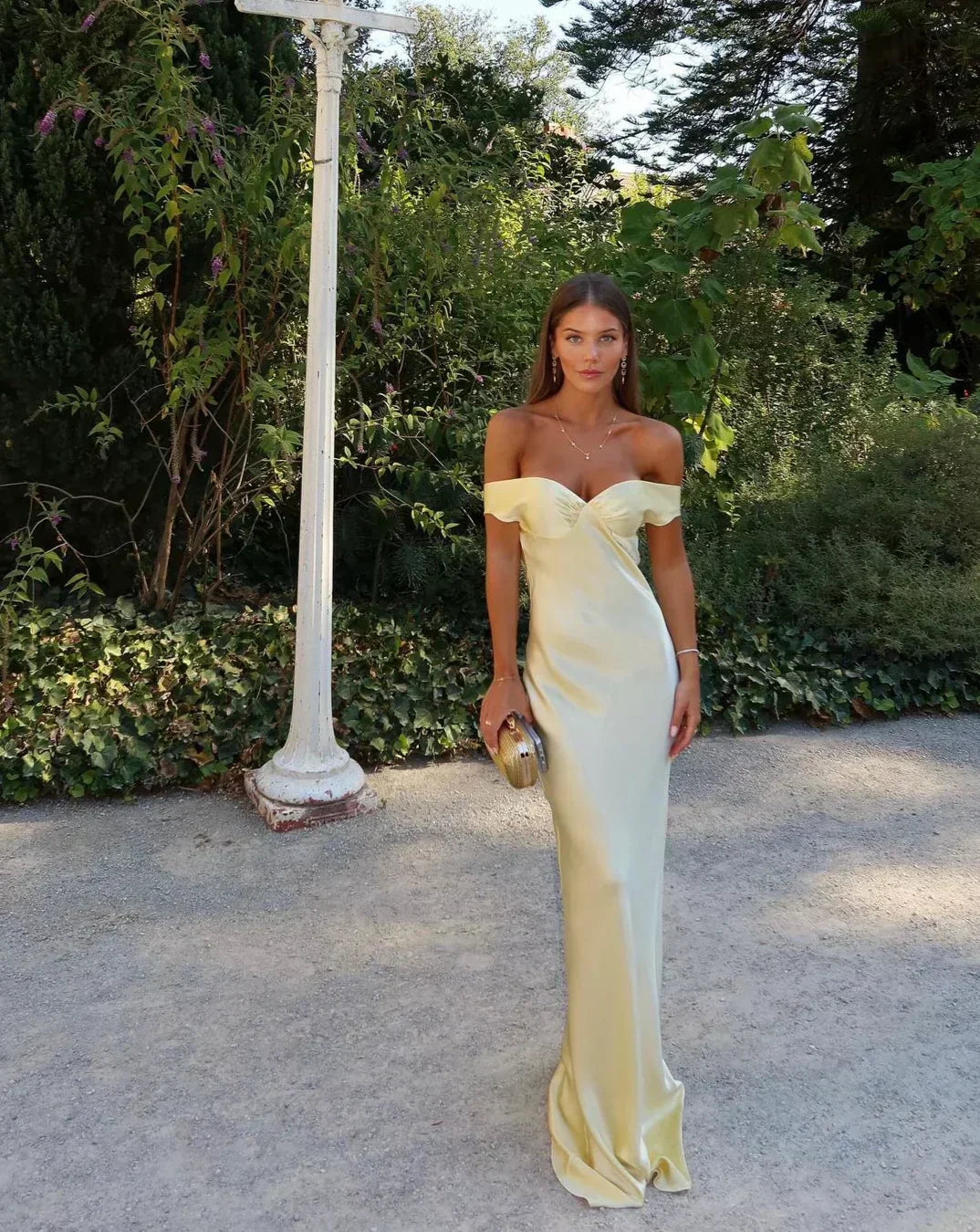 Elegant women's off-shoulder maxi dress with sweetheart neckline & bias cut. Gold formal gown for wedding guests.