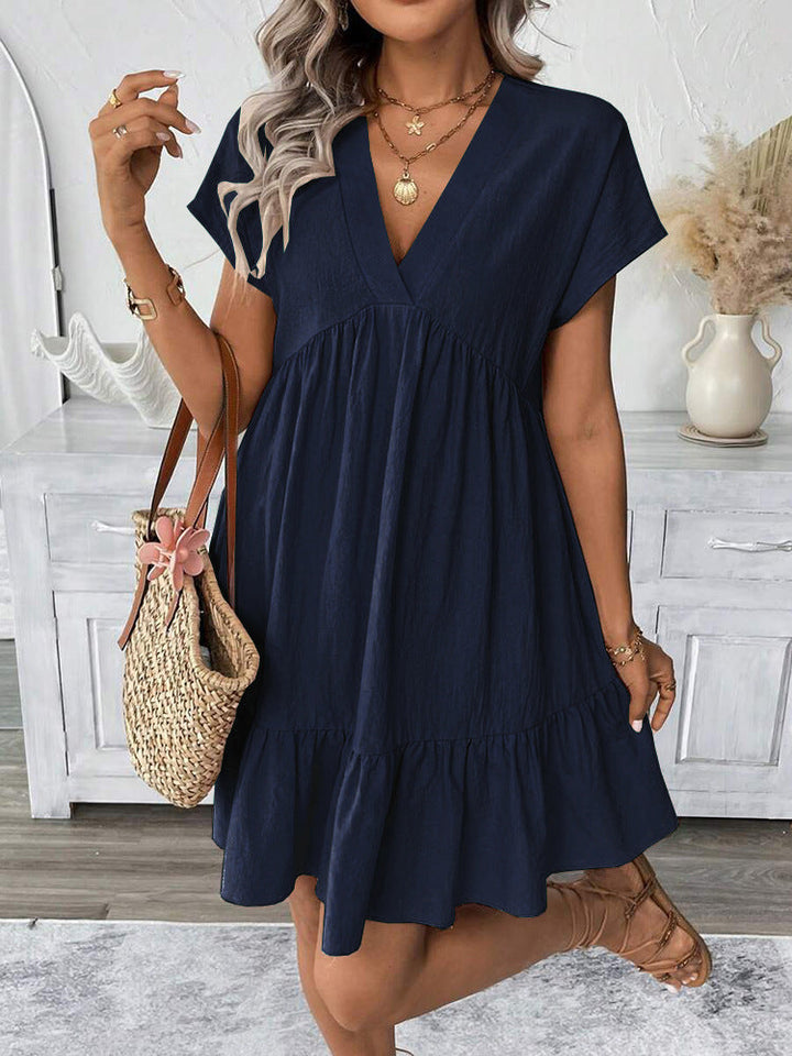 Elegant sleeveless V-neck mini dress for women, featuring a relaxed fit and playful ruffle hem, ideal for beach or party.