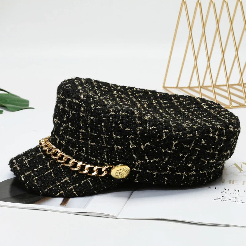 Stylish women's red tweed cap with a striking gold chain, a chic and modern fashion accessory.
