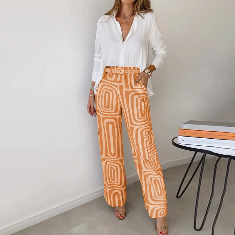 Fashionable women's chic two-piece set featuring a graceful flowing top and elegant patterned trousers.