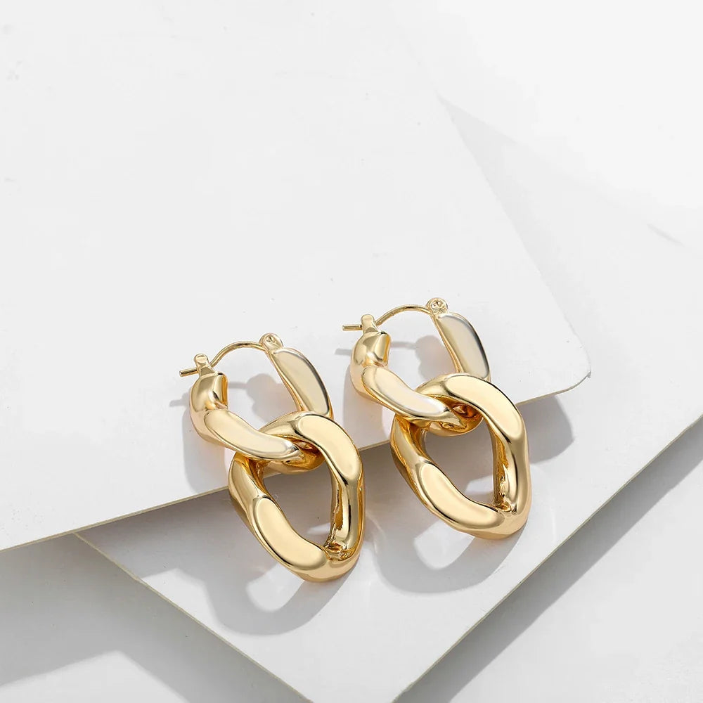 Close-up of women's chunky gold link drop earrings, showcasing the unique link design.