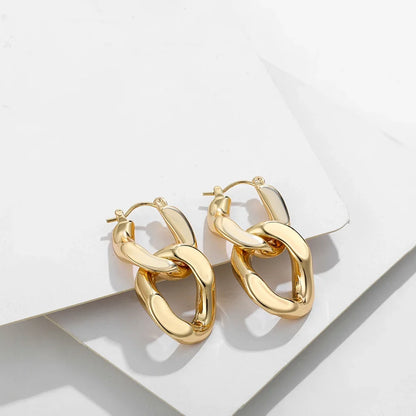Close-up of women's chunky gold link drop earrings, showcasing the unique link design.