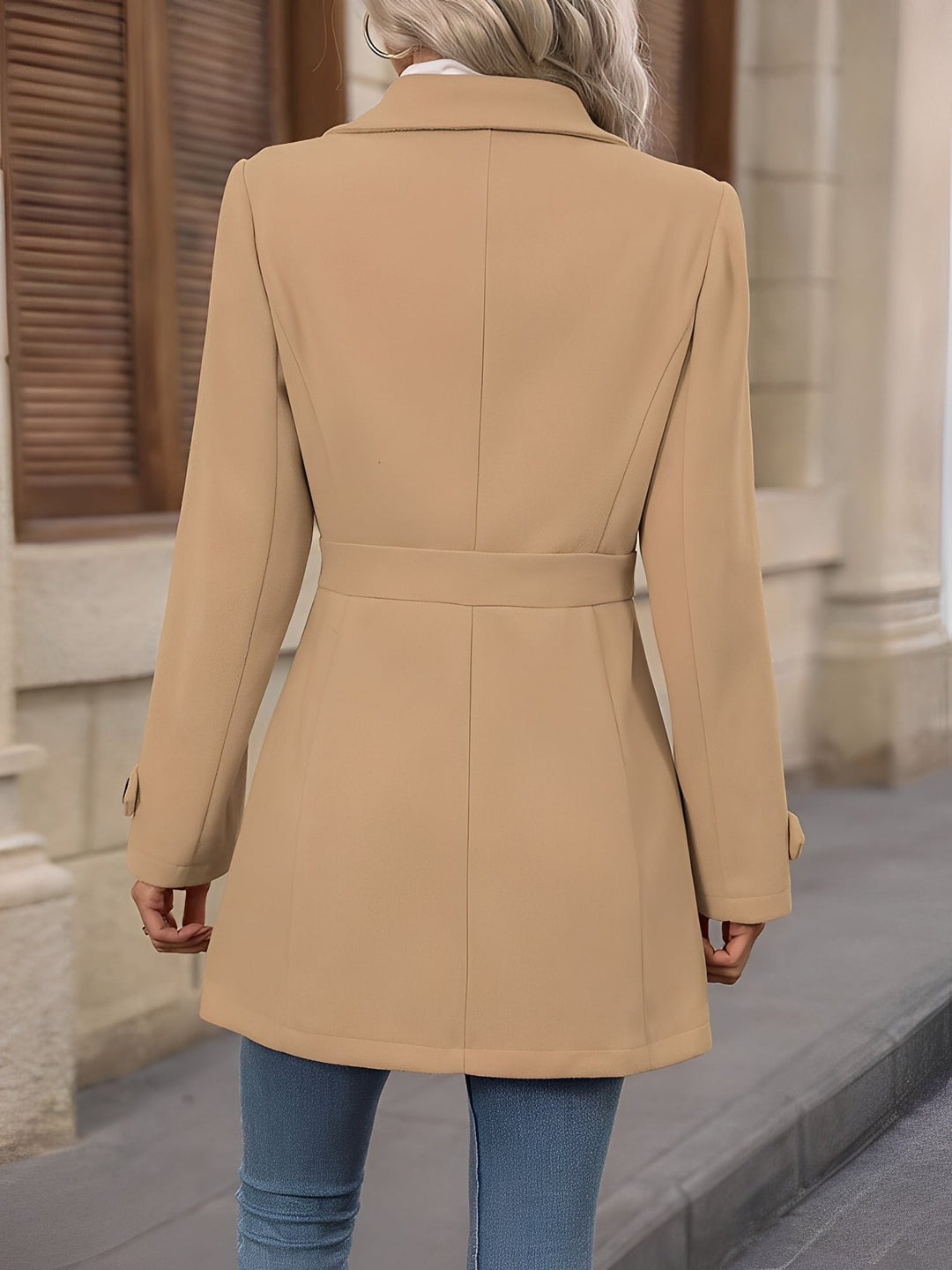 Elegant women's longline trench coat, sophisticated double-breasted design & adjustable belt.