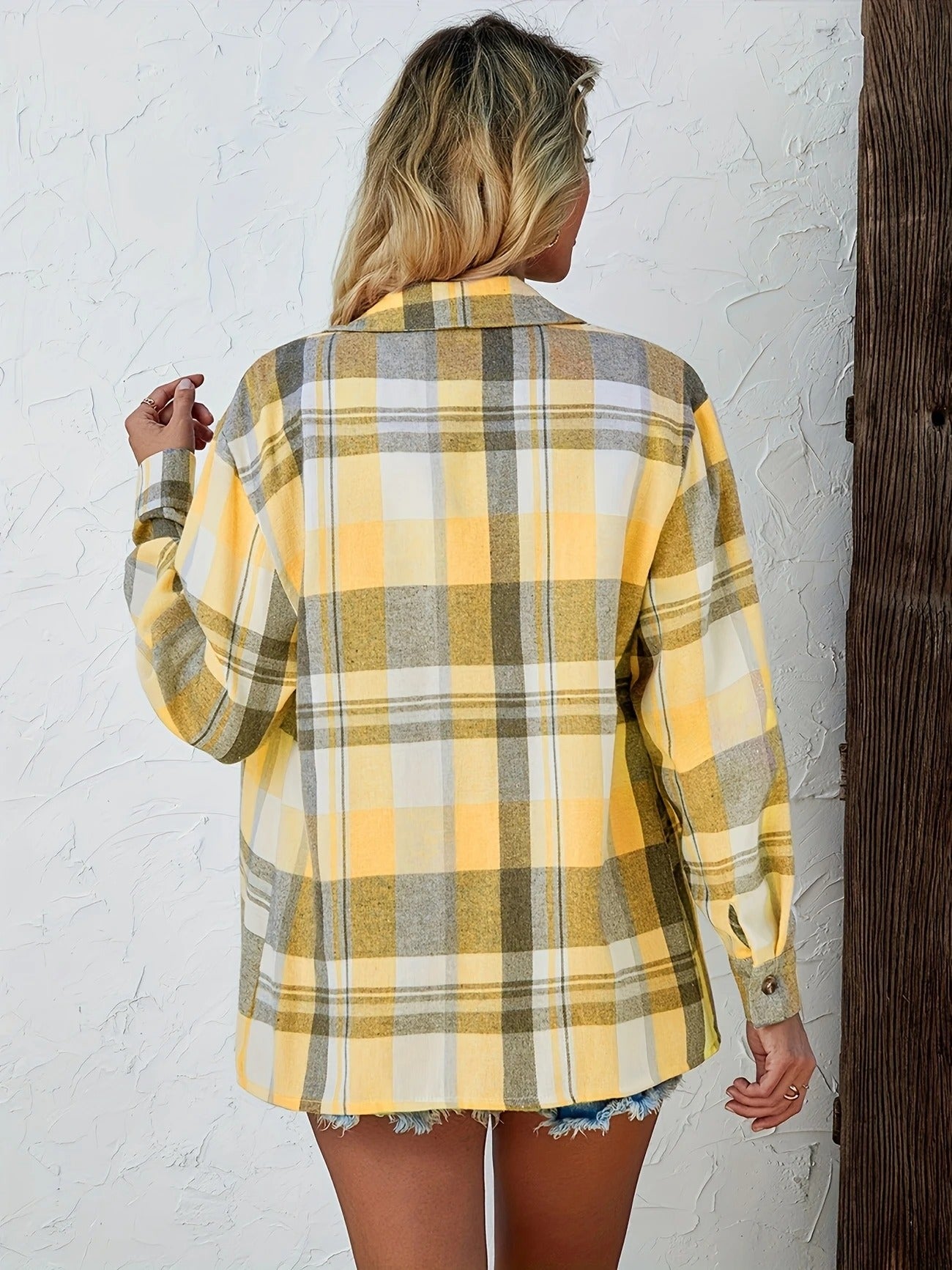 Women's classic plaid shirt, buttoned front, long sleeves rolled up for a relaxed, casual vibe.