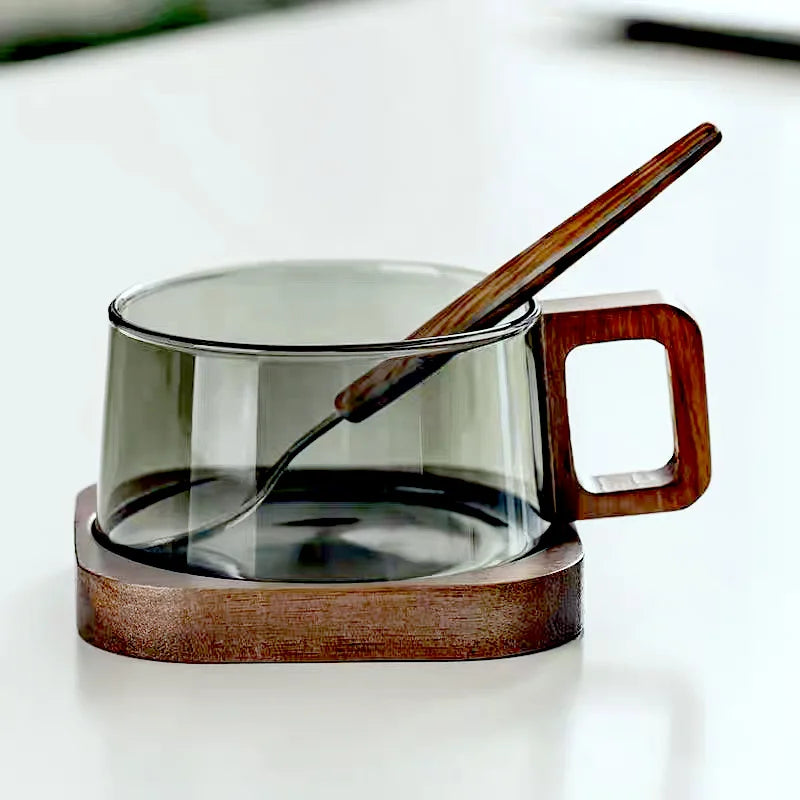 Clear borosilicate glass mug with a natural cedar wood handle, perfect for tea or coffee.
