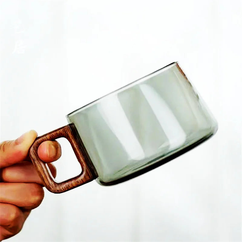 Modern clear glass mug with a comfortable cedar handle, excellent for hot or cold beverages.