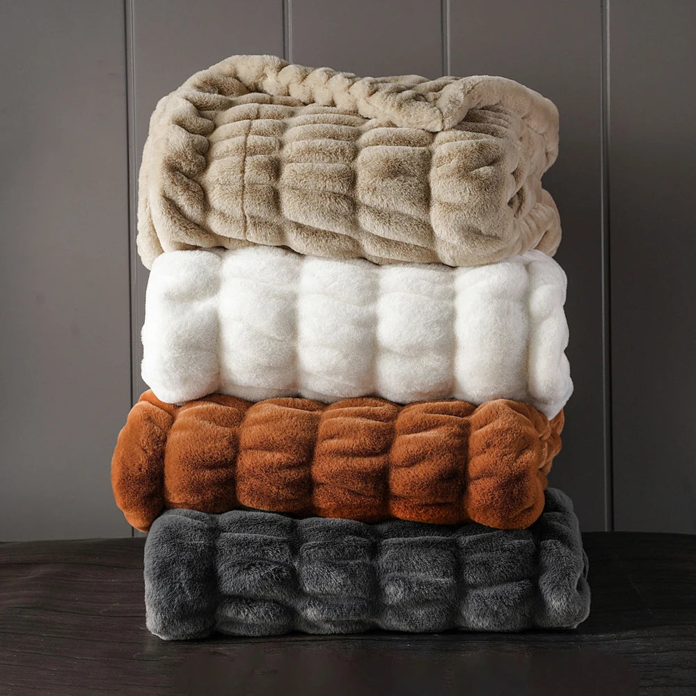 Close-up of luxurious faux rabbit fur throw blanket, showcasing plush texture & softness.