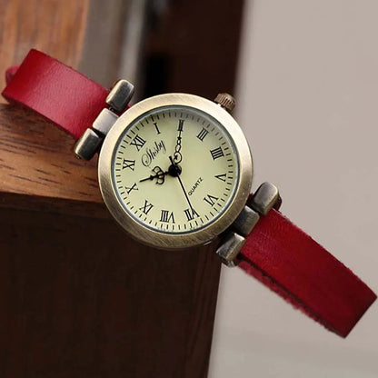 Classic women's timepiece, vintage design, white dial, slim brown leather band.