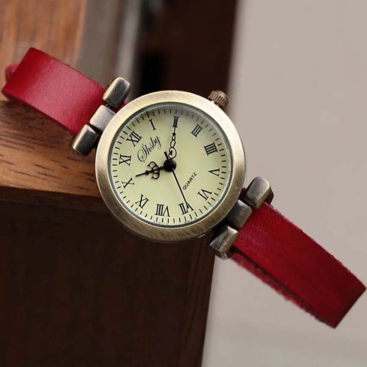 Classic women's timepiece, vintage design, white dial, slim brown leather band.