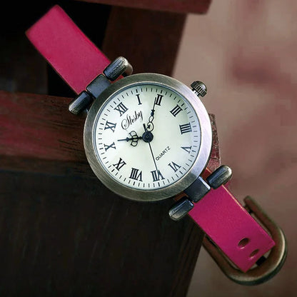 Close-up of the dial of a women's vintage quartz watch with subtle numbering and leather strap.