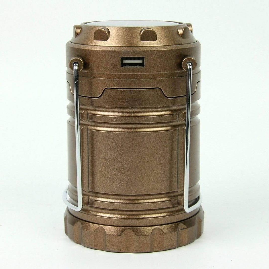 Collapsible LED camping lantern, fully extended, providing ambient light for an evening camp.