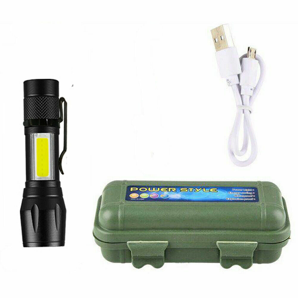 Hand holding a compact 900 lumen USB rechargeable tactical flashlight outdoors