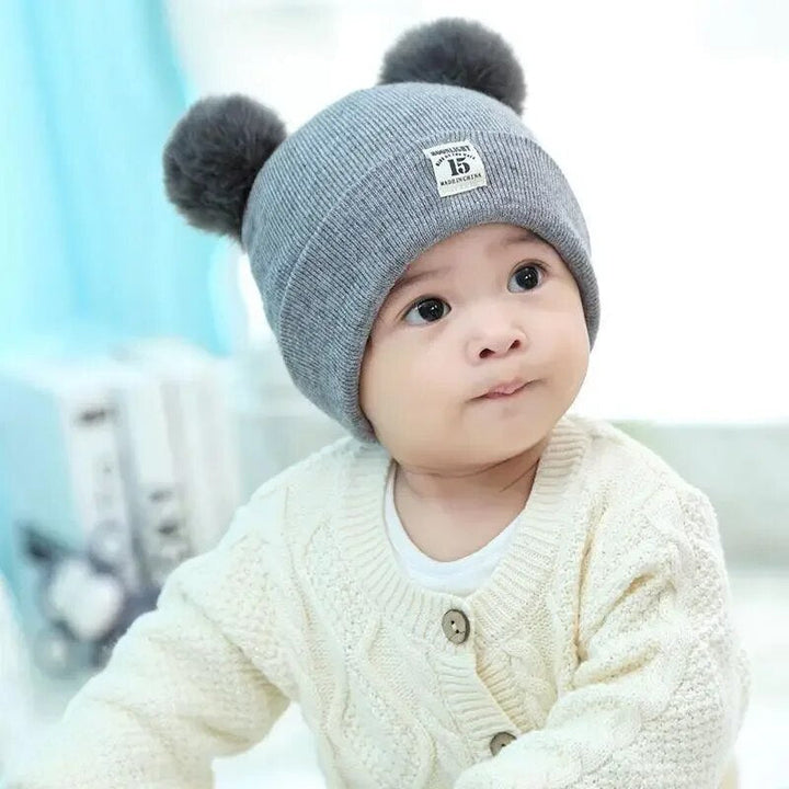 Soft knit winter hat for children. Features a cute pom-pom, perfect for boys & girls staying warm in style.