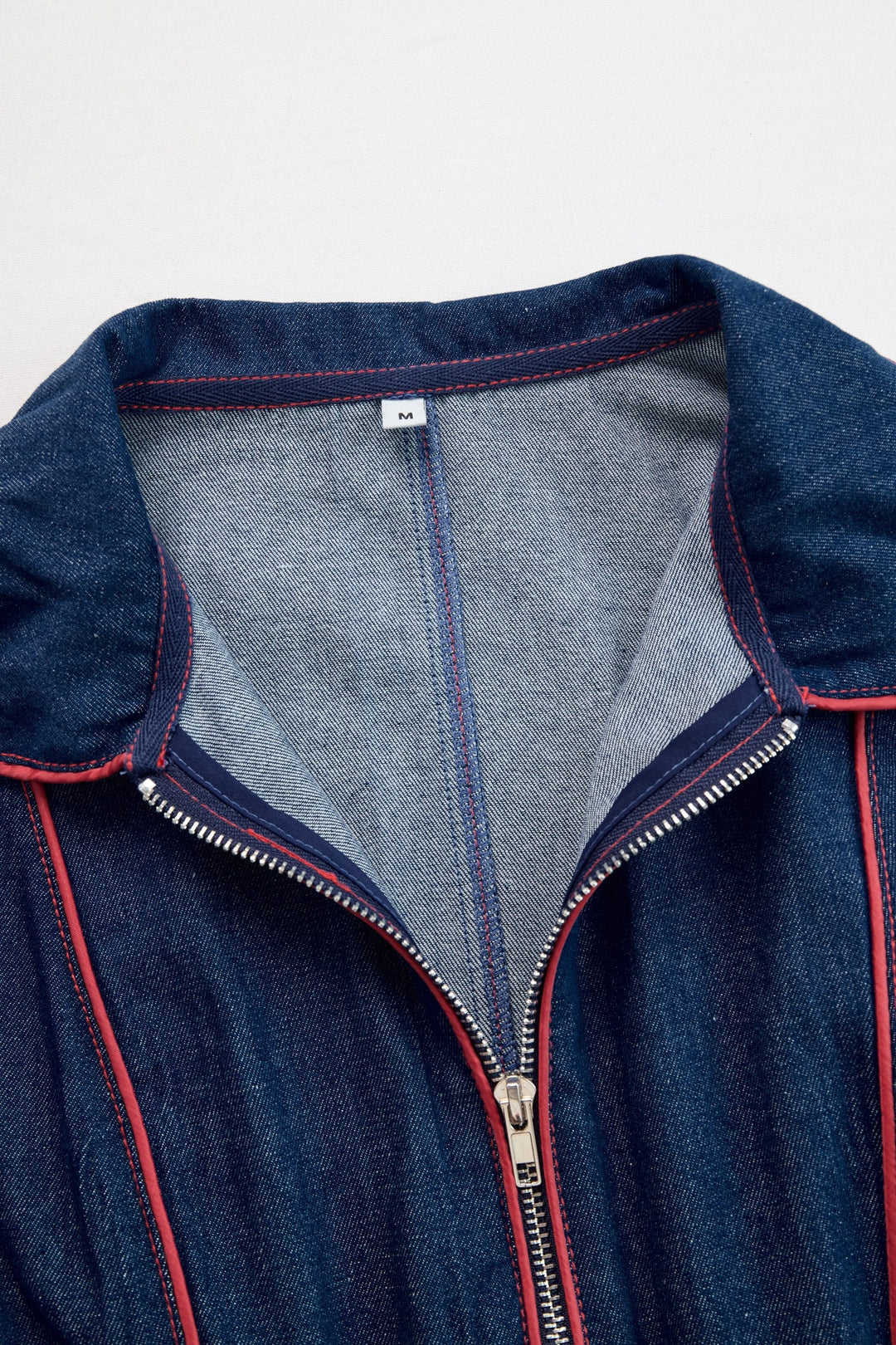 Full length view of a women's dark blue wide leg jumpsuit, a chic and comfortable outfit with a zip front.