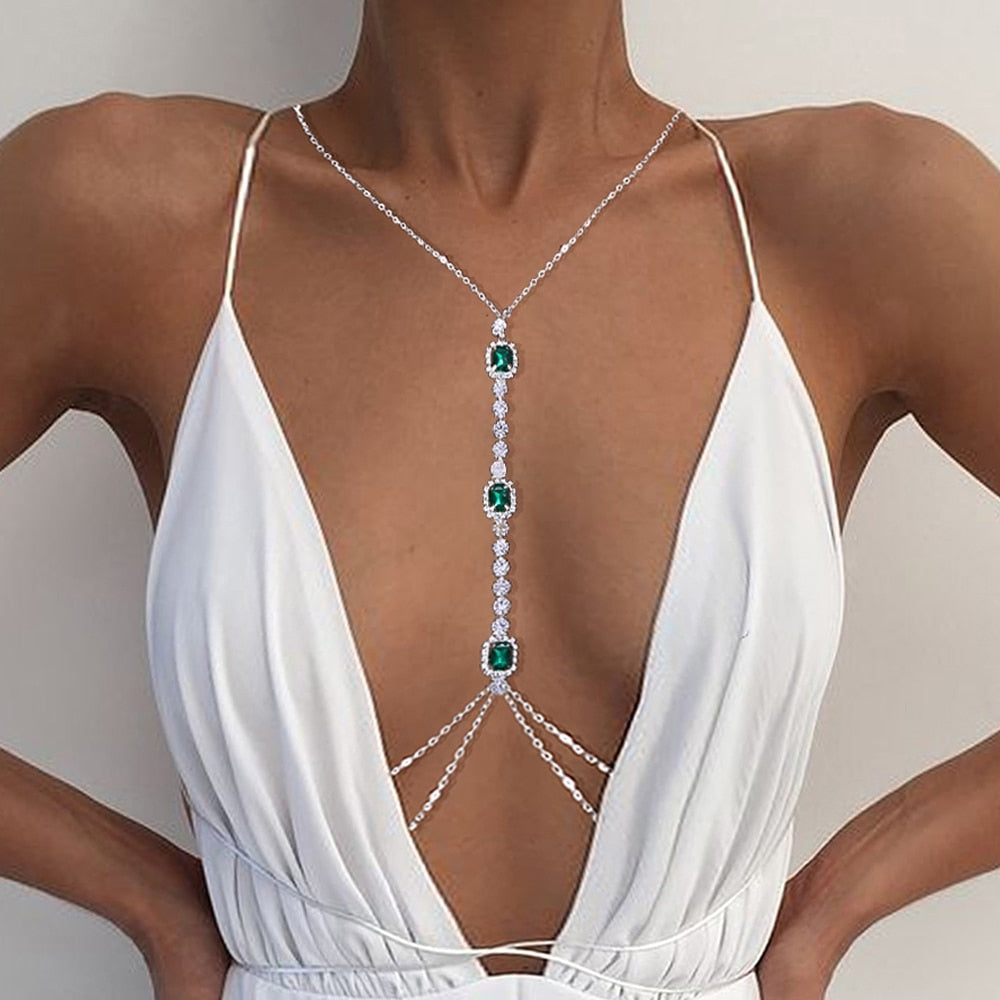 Sparkling green crystal chest chain for women. Rhinestone body jewelry, a dazzling statement piece for elegant style.