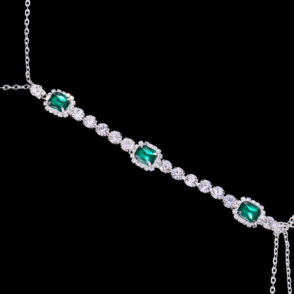 Green crystal chest chain for women. Dazzling rhinestone body jewelry, an elegant & sparkling statement accessory.