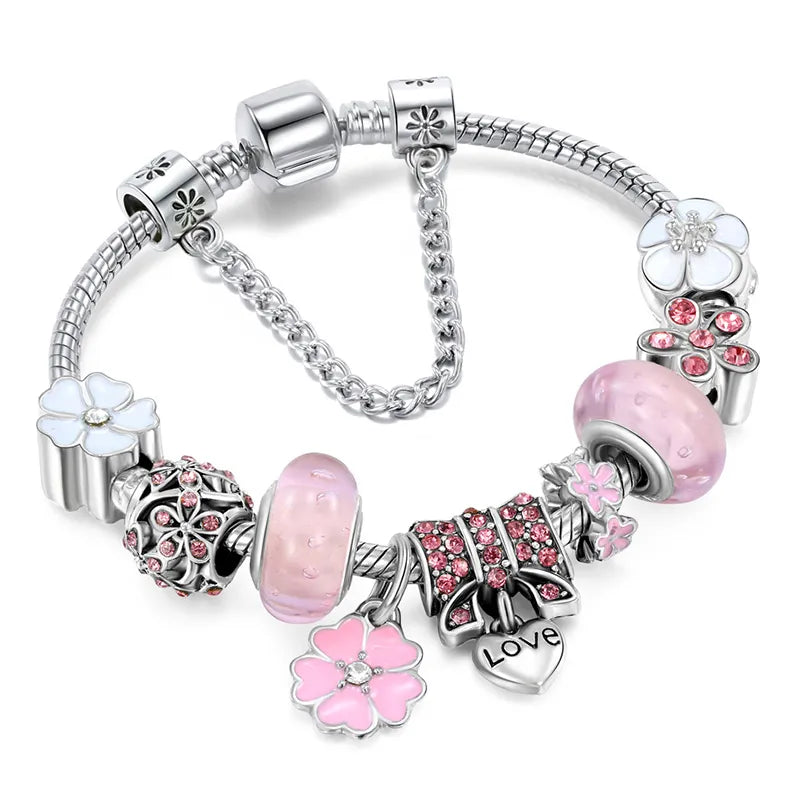 Close-up of elegant women's peach blossom charm bracelet. Adjustable stainless steel floral jewelry, perfect gift.