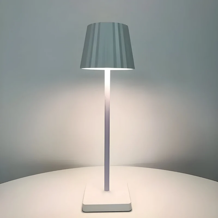 Wireless portable LED table lamp with touch control, rechargeable for indoor & outdoor ambiance.