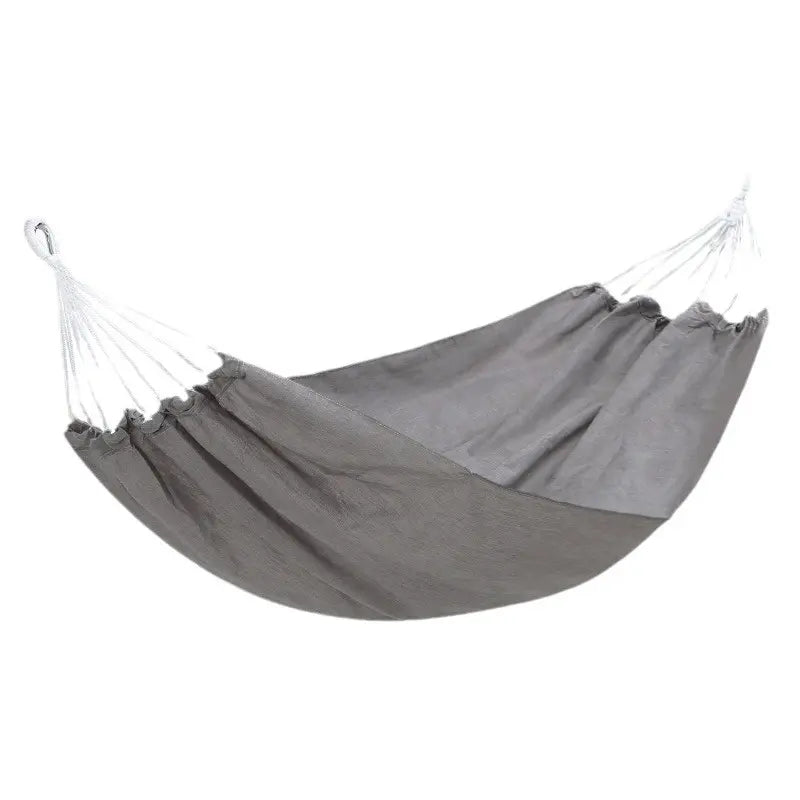 Enjoy ultimate relaxation: an anti-roll canvas hammock with sturdy spreader bars, perfect for outdoor lounging